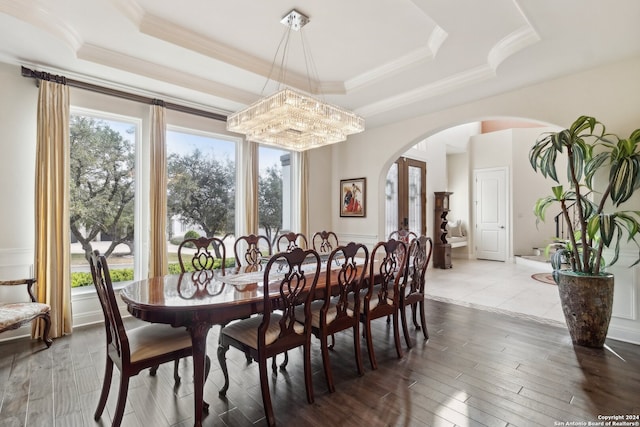 dining area featuring a chandelier, hardwood / wood-style floors, crown molding, and a raised ceiling