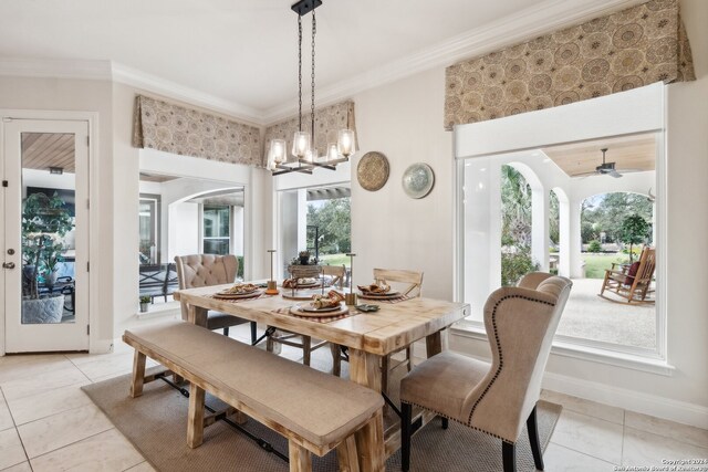 dining room featuring ornamental molding, ceiling fan with notable chandelier, and light tile patterned floors