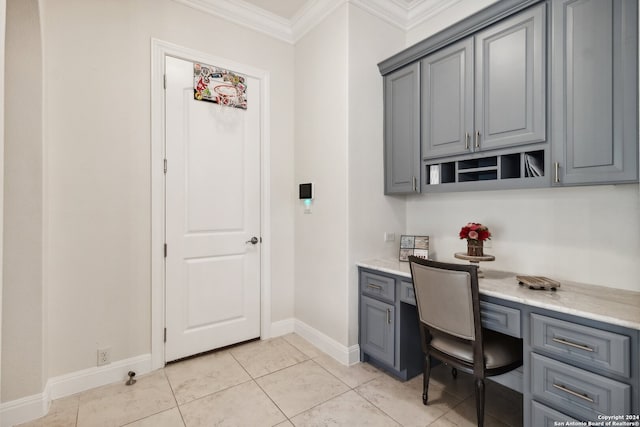 home office with built in desk, light tile patterned flooring, and ornamental molding