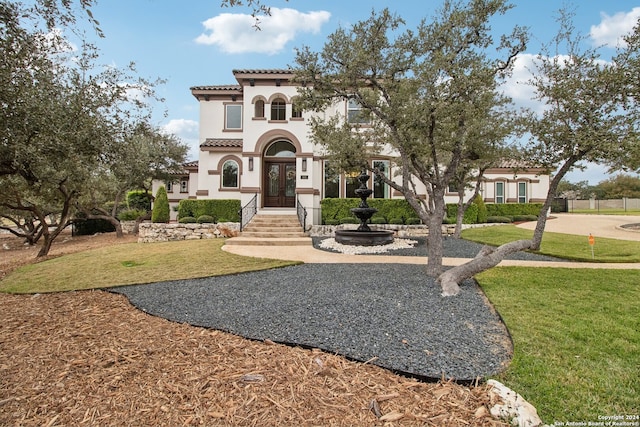 mediterranean / spanish-style house with a front yard