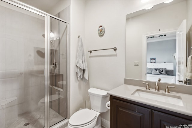 bathroom with a shower with door, vanity, and toilet