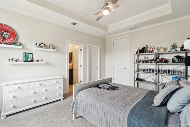 carpeted bedroom featuring connected bathroom, crown molding, ceiling fan, and a raised ceiling