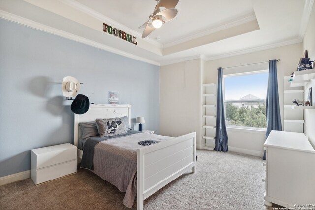 carpeted bedroom featuring ornamental molding, ceiling fan, and a raised ceiling