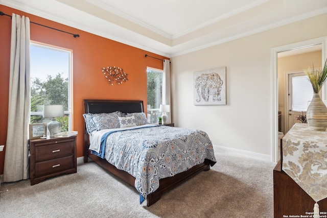 bedroom featuring light carpet, ornamental molding, and a raised ceiling