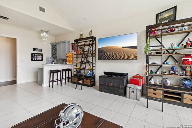 tiled living room featuring vaulted ceiling