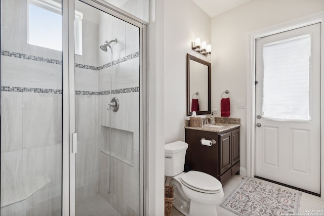 bathroom with a shower with shower door, vanity, and toilet