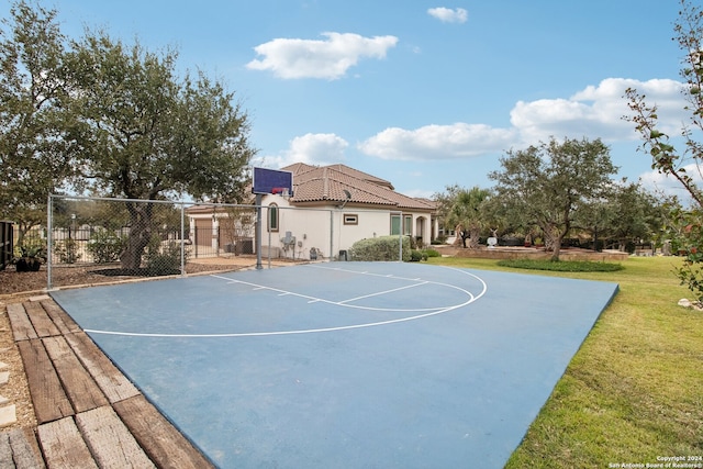 view of sport court with a lawn