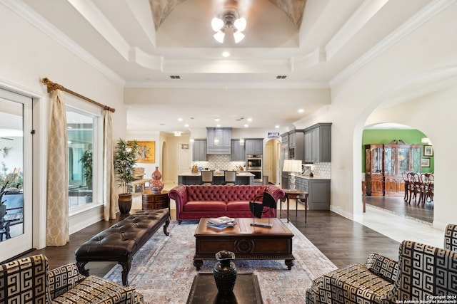 living room featuring ornamental molding, a healthy amount of sunlight, and dark hardwood / wood-style floors