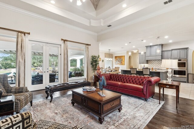 living room featuring wood-type flooring, ornamental molding, and french doors