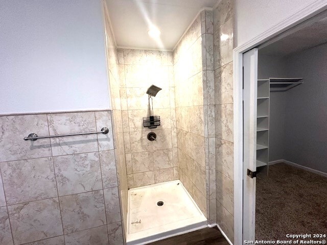 bathroom with tile walls and tiled shower