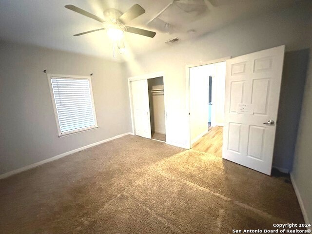 unfurnished bedroom with carpet floors, ceiling fan, and a closet