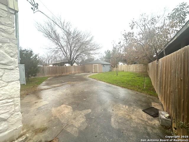 view of yard featuring a storage shed and a patio