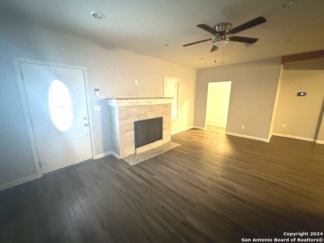 unfurnished living room with ceiling fan and dark hardwood / wood-style flooring