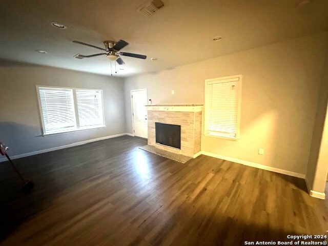 unfurnished living room featuring dark hardwood / wood-style flooring and ceiling fan