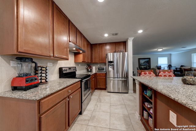 kitchen with appliances with stainless steel finishes, light tile patterned flooring, and light stone countertops