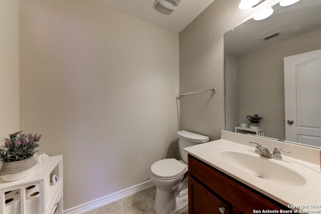 bathroom featuring tile patterned flooring, vanity, and toilet