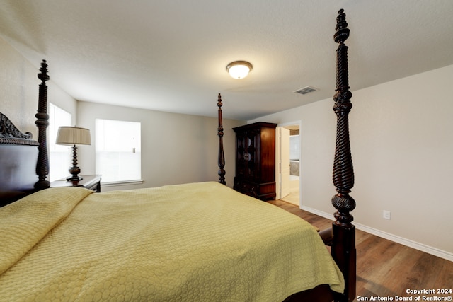 bedroom featuring hardwood / wood-style flooring and ensuite bath