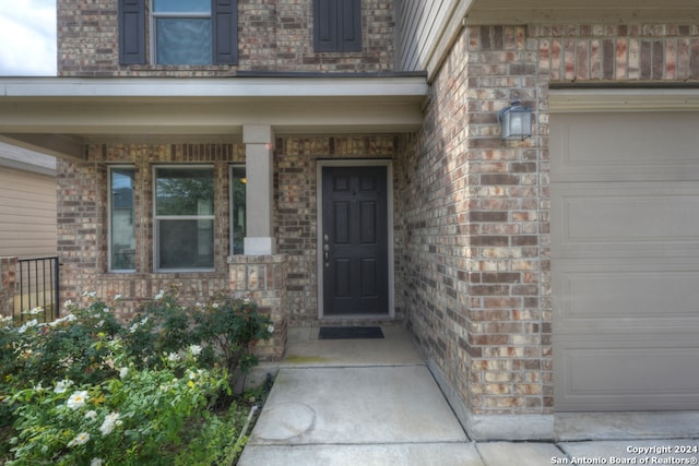 entrance to property featuring a garage and covered porch