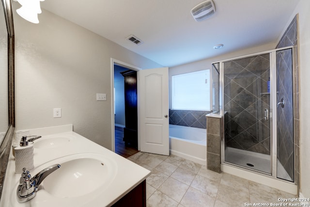 bathroom featuring shower with separate bathtub, vanity, and tile patterned flooring