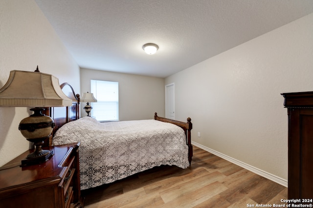 bedroom featuring hardwood / wood-style floors and a textured ceiling