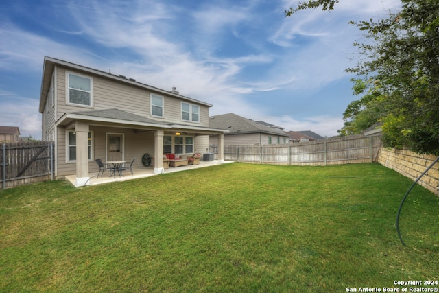 rear view of house featuring a lawn, cooling unit, and a patio area