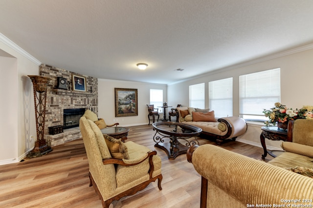 living room featuring a brick fireplace, a textured ceiling, hardwood / wood-style flooring, and crown molding