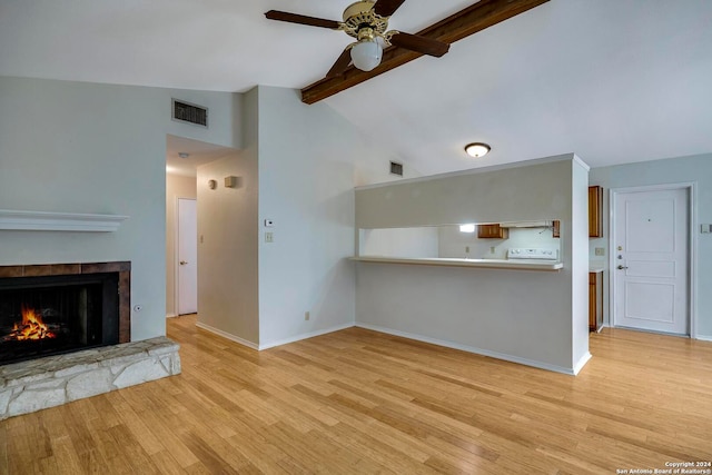 unfurnished living room featuring a fireplace, light wood-type flooring, and lofted ceiling with beams