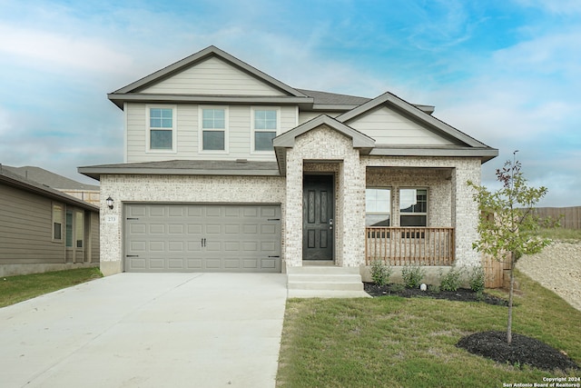 view of front of property with a garage, a front yard, and a porch