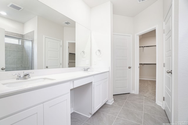 bathroom featuring walk in shower, vanity, and tile patterned flooring