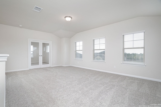 unfurnished room featuring carpet flooring, french doors, and vaulted ceiling