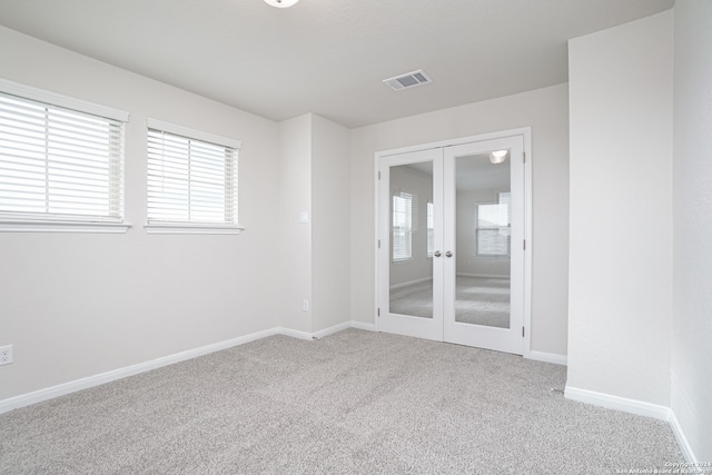 unfurnished room with french doors and carpet floors