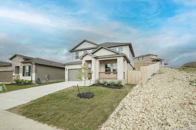 view of front of home featuring covered porch, a garage, and a front yard