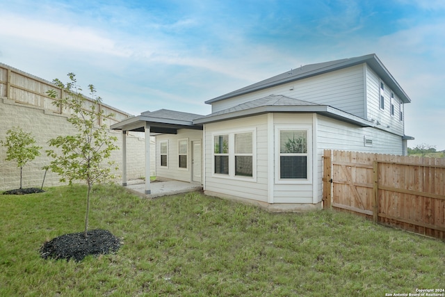 rear view of property featuring a lawn and a patio area