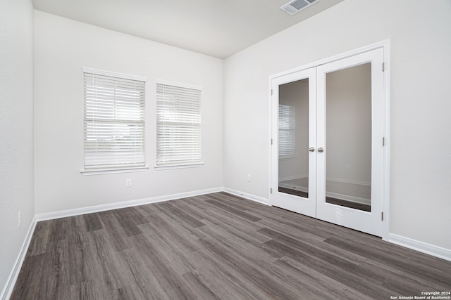 empty room with dark hardwood / wood-style floors and french doors