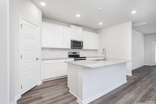 kitchen with white cabinets, stainless steel appliances, and an island with sink