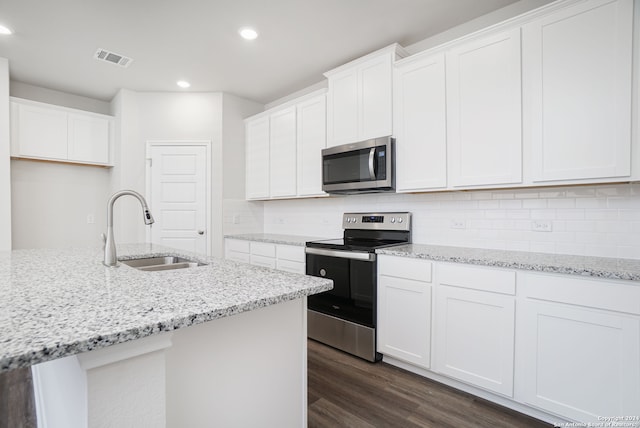 kitchen featuring stainless steel appliances, dark wood-type flooring, sink, light stone countertops, and white cabinetry