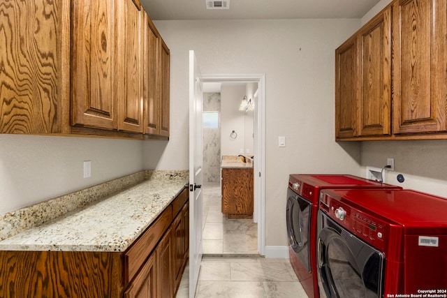 laundry room featuring cabinets, sink, and washing machine and clothes dryer