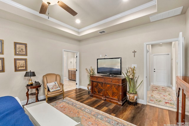 bedroom with dark hardwood / wood-style flooring, ensuite bathroom, ceiling fan, a raised ceiling, and crown molding