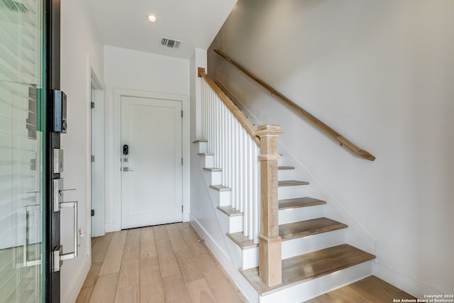 stairs featuring hardwood / wood-style floors