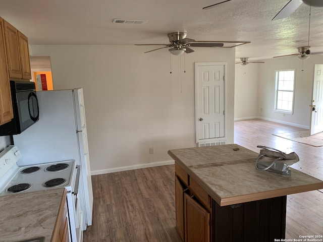 kitchen with electric range, hardwood / wood-style floors, and a textured ceiling