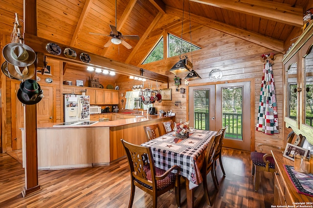 dining space featuring beamed ceiling, wood walls, and light hardwood / wood-style flooring