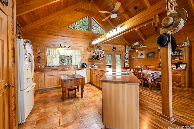 kitchen with white appliances, light brown cabinets, wooden ceiling, beamed ceiling, and wood walls