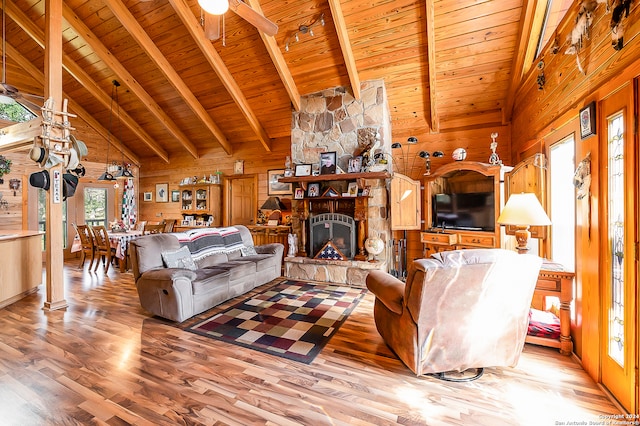 living room featuring wood ceiling, wooden walls, a fireplace, and light hardwood / wood-style floors