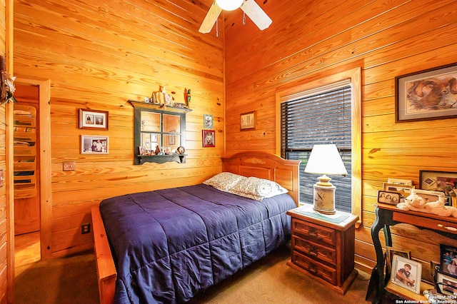 bedroom with carpet flooring, ceiling fan, and wooden walls