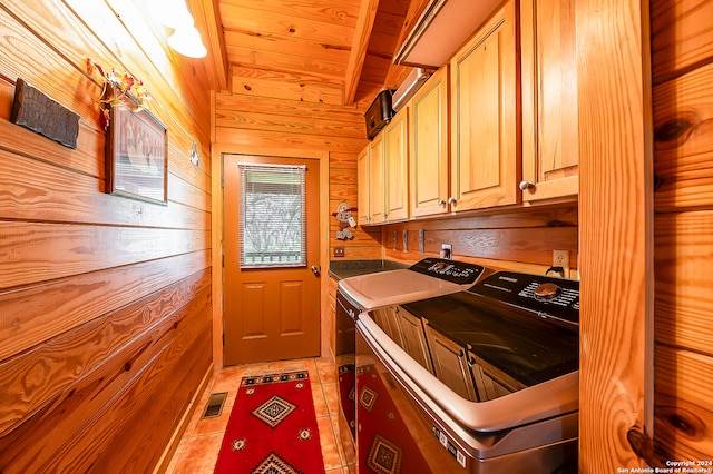 laundry room with cabinets, dark tile patterned floors, wooden ceiling, independent washer and dryer, and wood walls