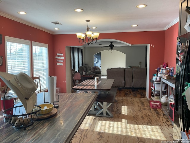 dining room with hardwood / wood-style floors, ornamental molding, and ceiling fan with notable chandelier