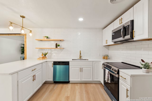 kitchen featuring white cabinetry, kitchen peninsula, appliances with stainless steel finishes, and sink