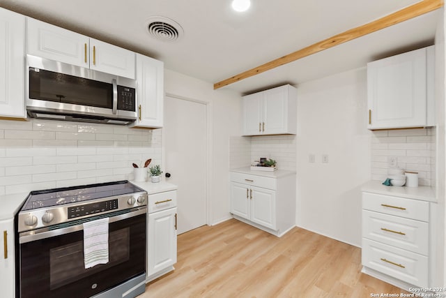 kitchen featuring stainless steel appliances, light hardwood / wood-style floors, white cabinetry, and tasteful backsplash