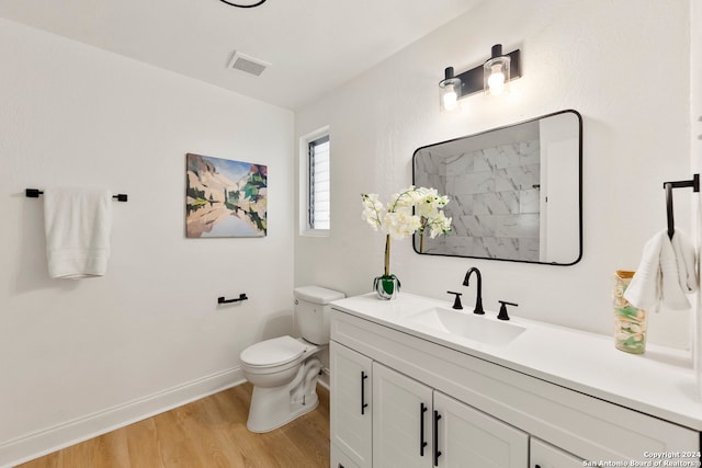 bathroom featuring hardwood / wood-style floors, vanity, toilet, and a shower