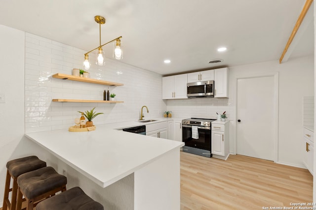 kitchen with stainless steel appliances, white cabinetry, light wood-type flooring, hanging light fixtures, and kitchen peninsula